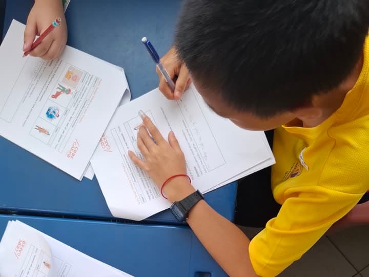 A student writing up their project reflection on a worksheet