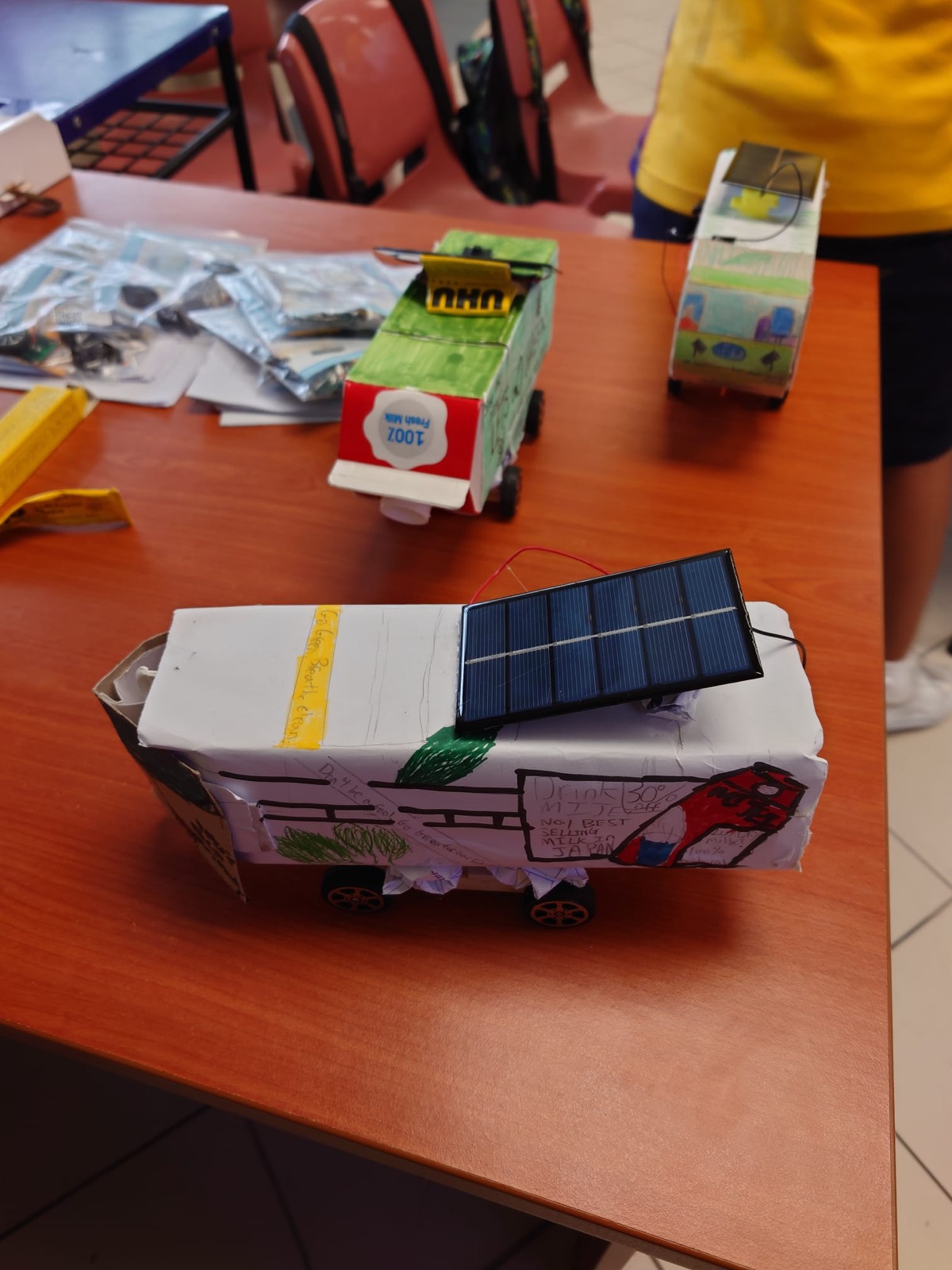 Student prototypes at the build stage — each team decorated and engineered its own bus.